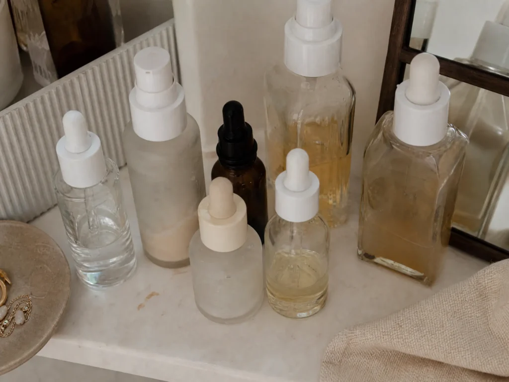 10 Best Centella Asiatica (Cica) Serums in India (2026) 2 Multiple half-used skincare serum bottles cluttered on a shelf, representing common Indian skincare shopping mistakes
