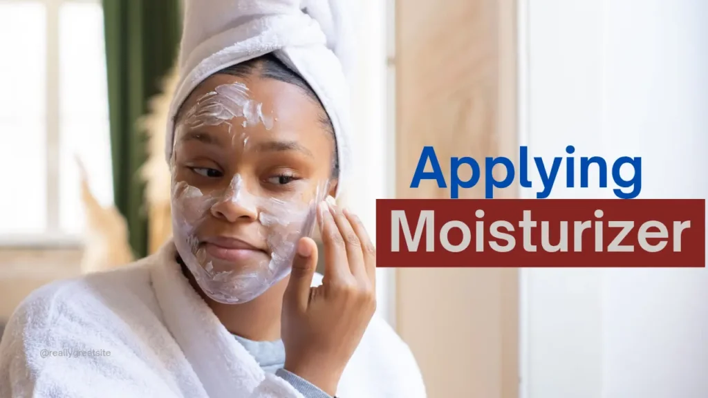 Woman applying moisturizer on damp face after cleansing
